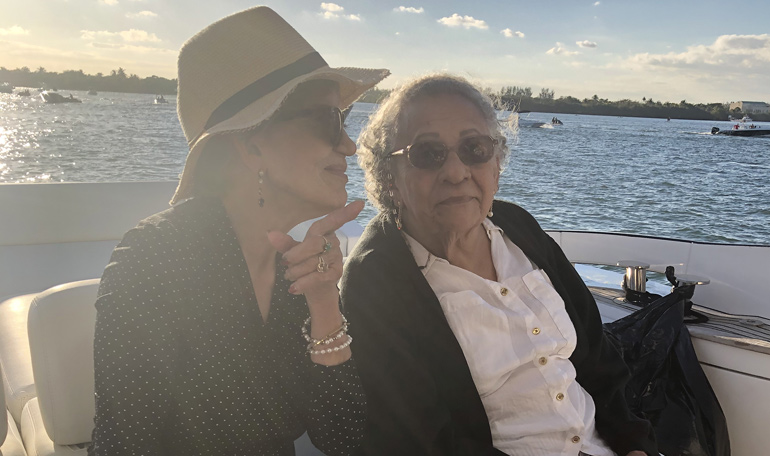 A mother and daughter share a conversation during sunset on their mothers day yacht charter.